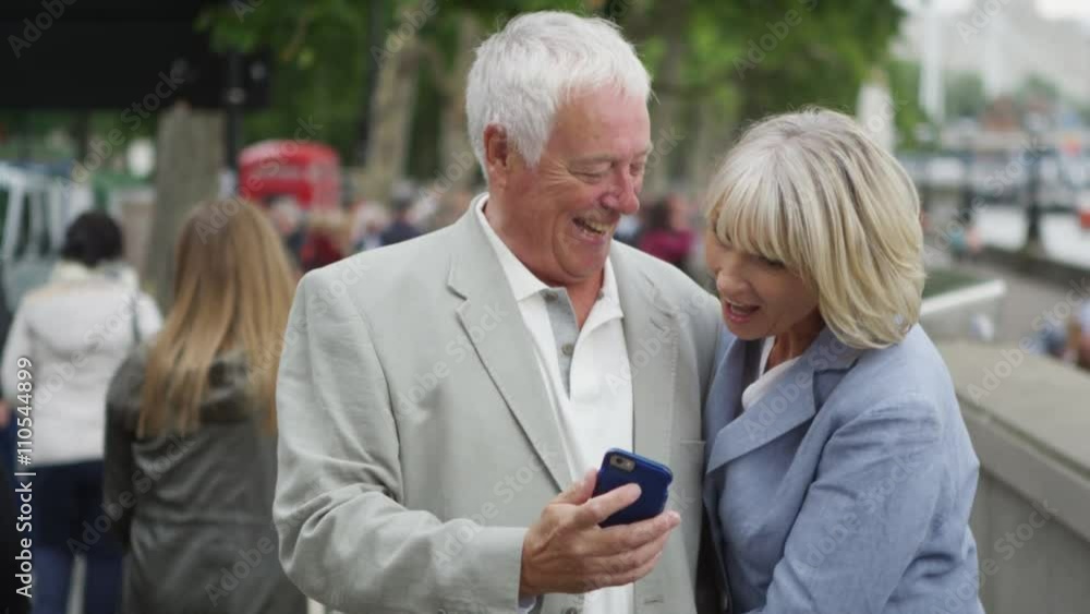 Romantic mature couple in London, pose to take a selfie with mobile phone Romantic mature couple in London, pose to take a selfie with mobile phone