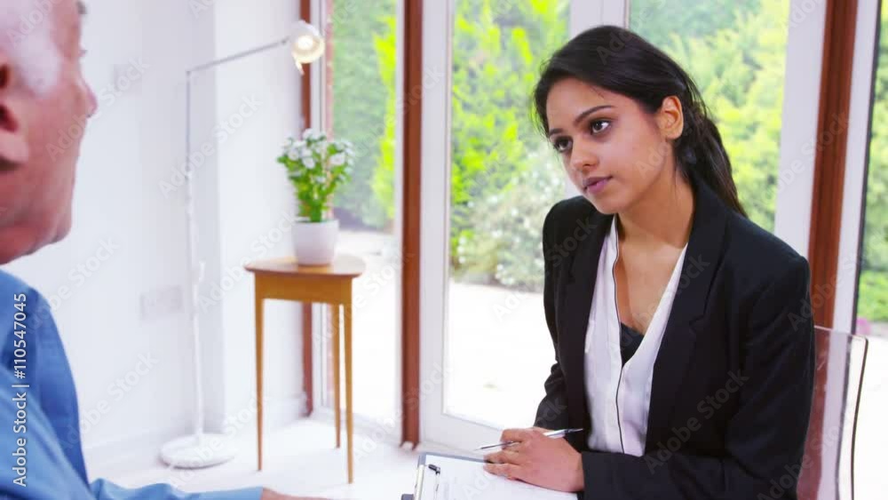 Senior man talking to young woman in office setting Senior man talking to young woman in office setting