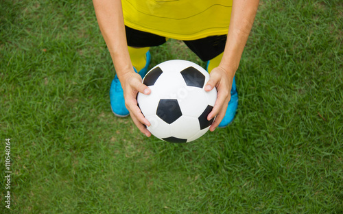 Soccer player holding a football. © sirikornt