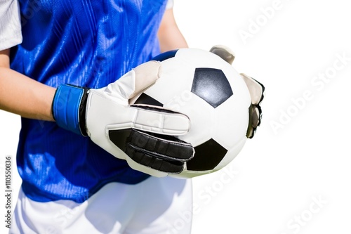 Close up of a football held by sportswoman 