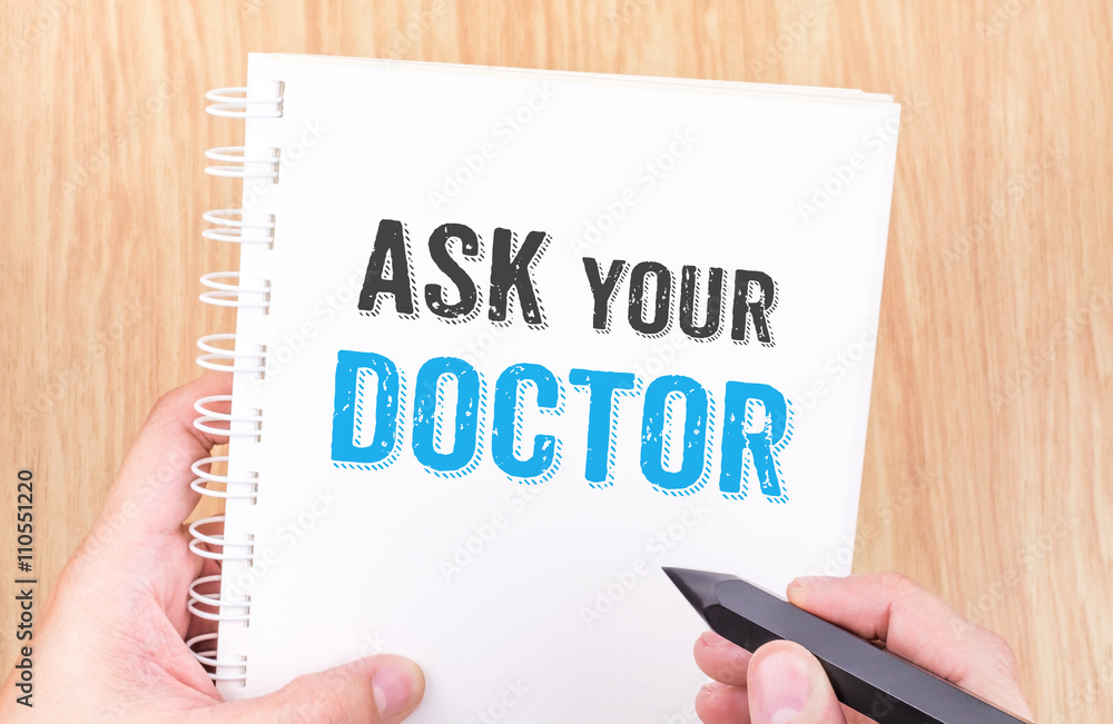 Ask your doctor word on white ring binder notebook with hand hol Ask your doctor word on white ring binder notebook with hand hol