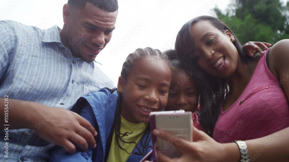 Happy family having fun in the park pose to take a selfie with mobile phone. Happy family having fun in the park pose to take a selfie with mobile phone.