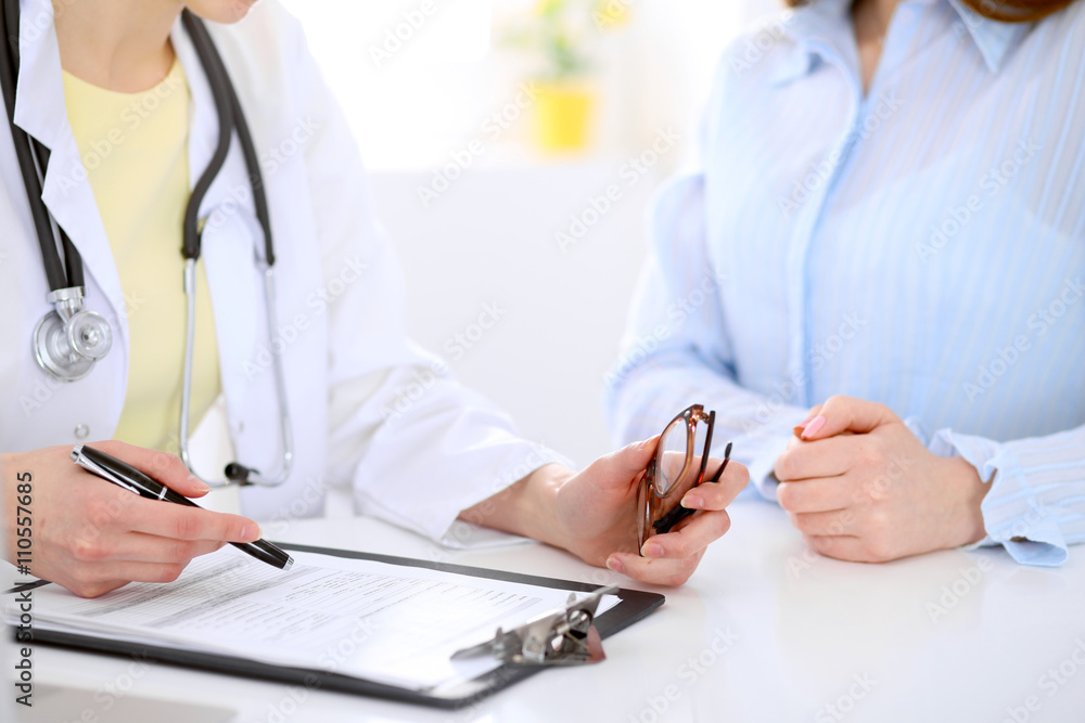 Doctor and patient are discussing something, just hands at the table Doctor and patient are discussing something, just hands at the table