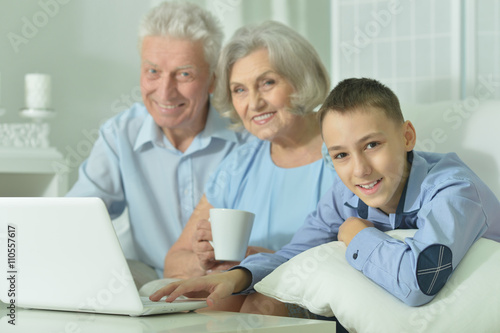 Boy with his grandparents and laptop