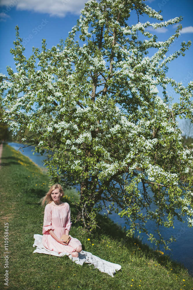 beautiful girl in dress sitting under the apple blossom beautiful girl in dress sitting under the apple blossom