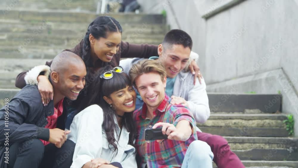 Happy mixed ethnicity friends outdoors in the city pose to take a selfie Happy mixed ethnicity friends outdoors in the city pose to take a selfie