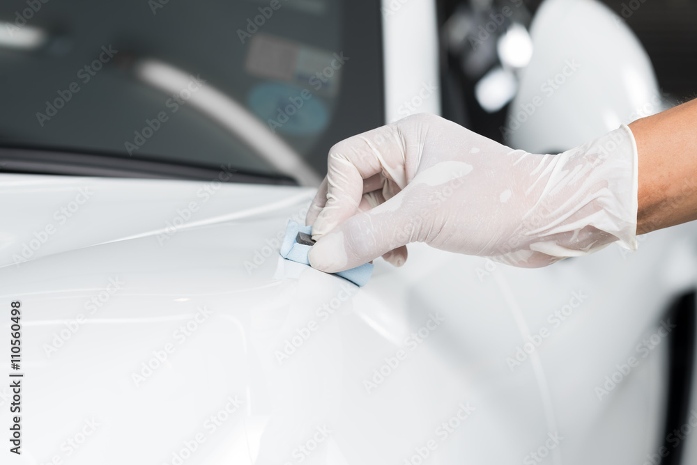 Car detailing series : Closeup of hand  coating white car paint