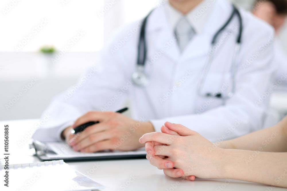 Doctor and patient are discussing something, just hands at the table Doctor and patient are discussing something, just hands at the table