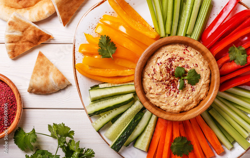 Homemade hummus with assorted fresh vegetables and pita bread.