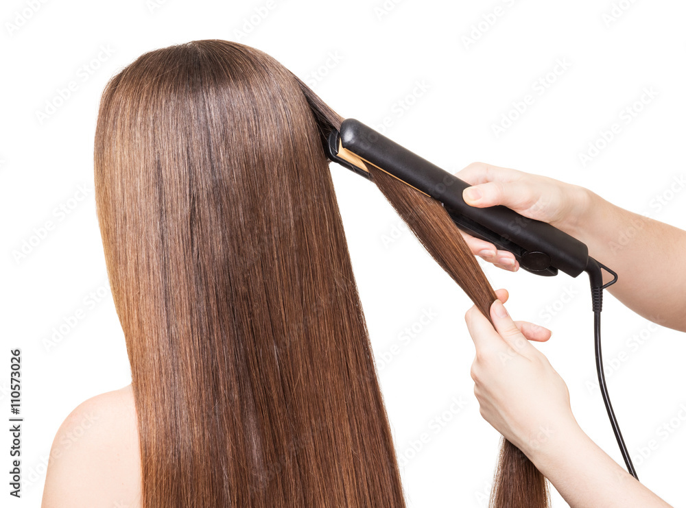 Fototapeta premium Makeup artist aligns long hair Curling on white
