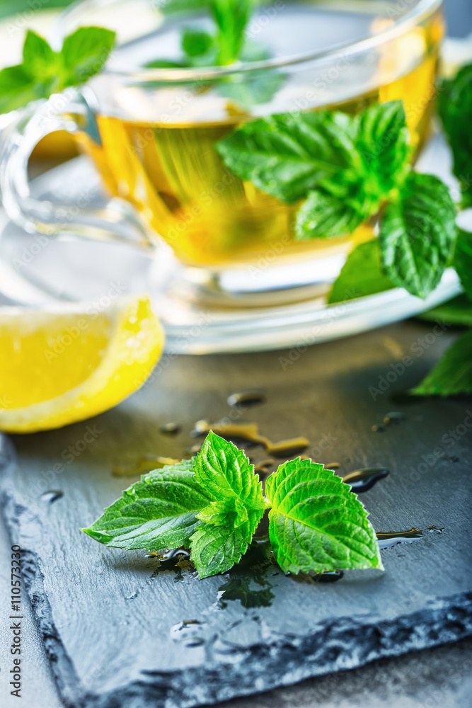 Mint leaf. Mint leaves. Tea. Mint Tea. Herbal tea. Tea in a glass cup, mint leaves, dried tea, sliced lime. herbs tea and mint leaves on a slate plate in a restaurant or teahouse tea room. Mint leaf. Mint leaves. Tea. Mint Tea. Herbal tea. Tea in a glass cup, mint leaves, dried tea, sliced lime. herbs tea and mint leaves on a slate plate in a restaurant or teahouse tea room.