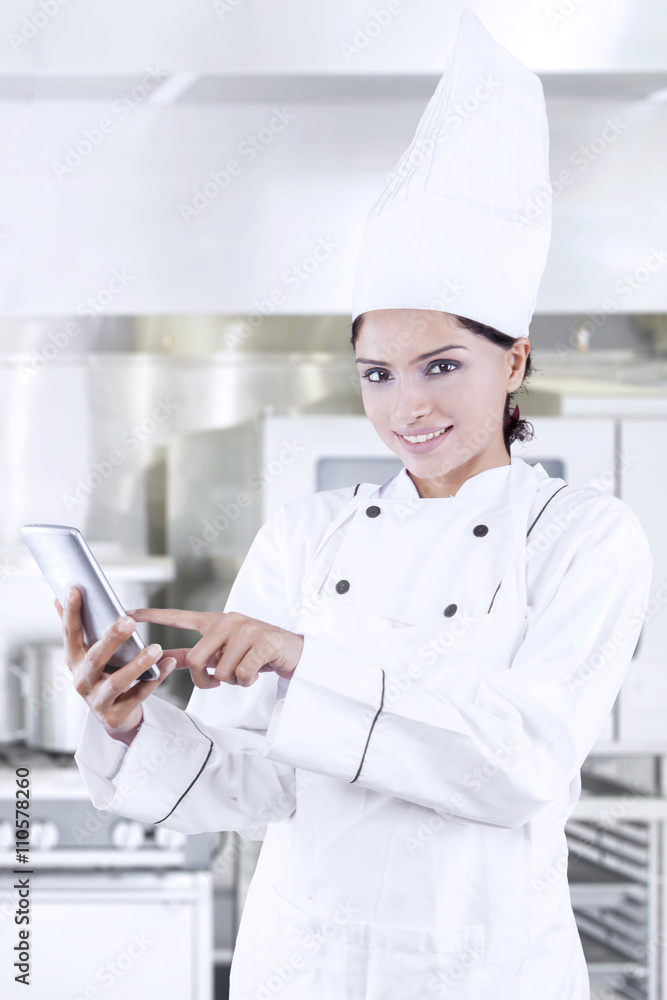 Asian chef using cellphone in kitchen Asian chef using cellphone in kitchen
