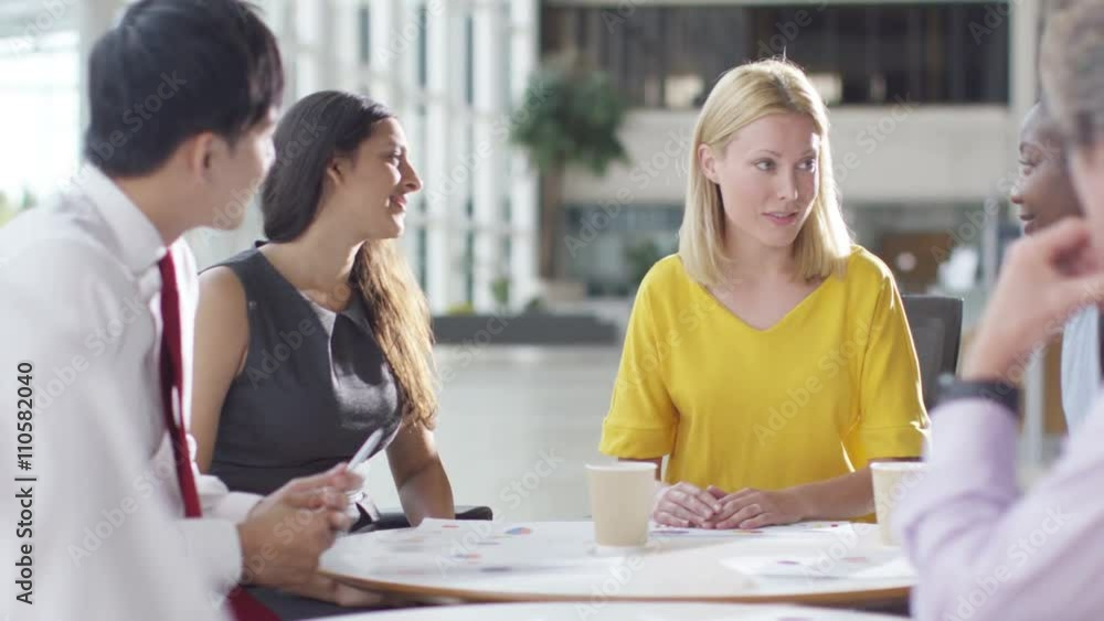  Attractive mixed ethnicity business group discuss ideas in office meeting