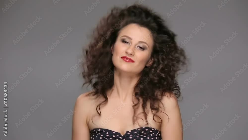 Young brunette with long brown curly hair dancing Young brunette with long brown curly hair dancing