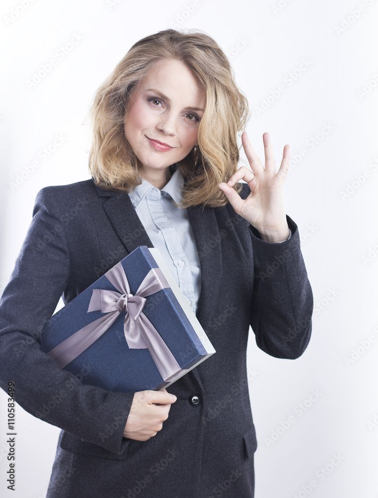 Happy business woman with a gift. Portrait of a blonde in a jacket on a white.
Happy business woman with a gift. Portrait of a blonde in a jacket on a white.
