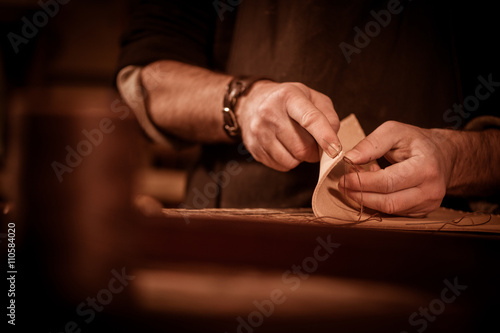 Leather goods craftsman at work in his workshop