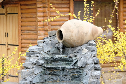 Decorative garden waterfall with stone jar photo