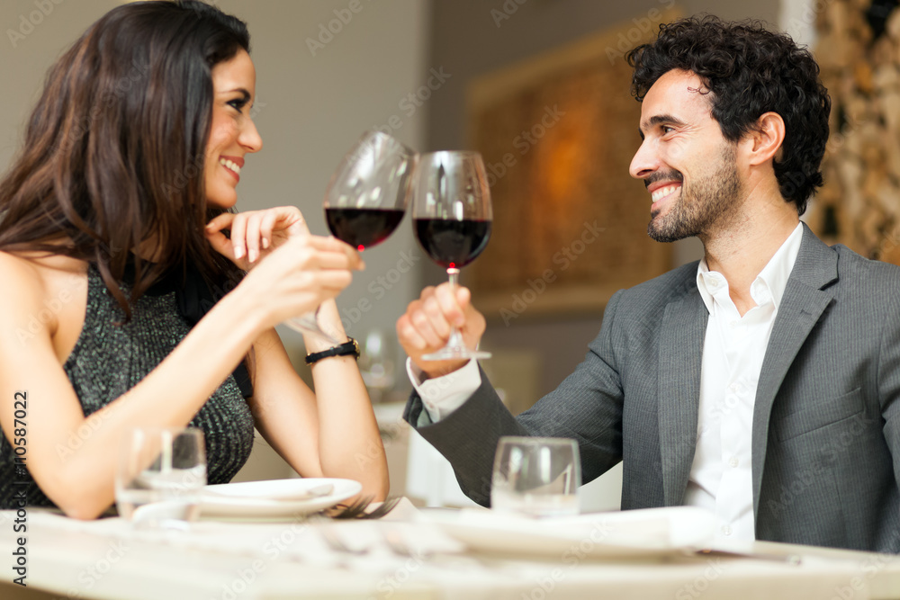 Young coupple toasting wine glasses in a restaurant Young coupple toasting wine glasses in a restaurant