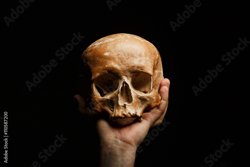 hand holding a skull is isolated on black background