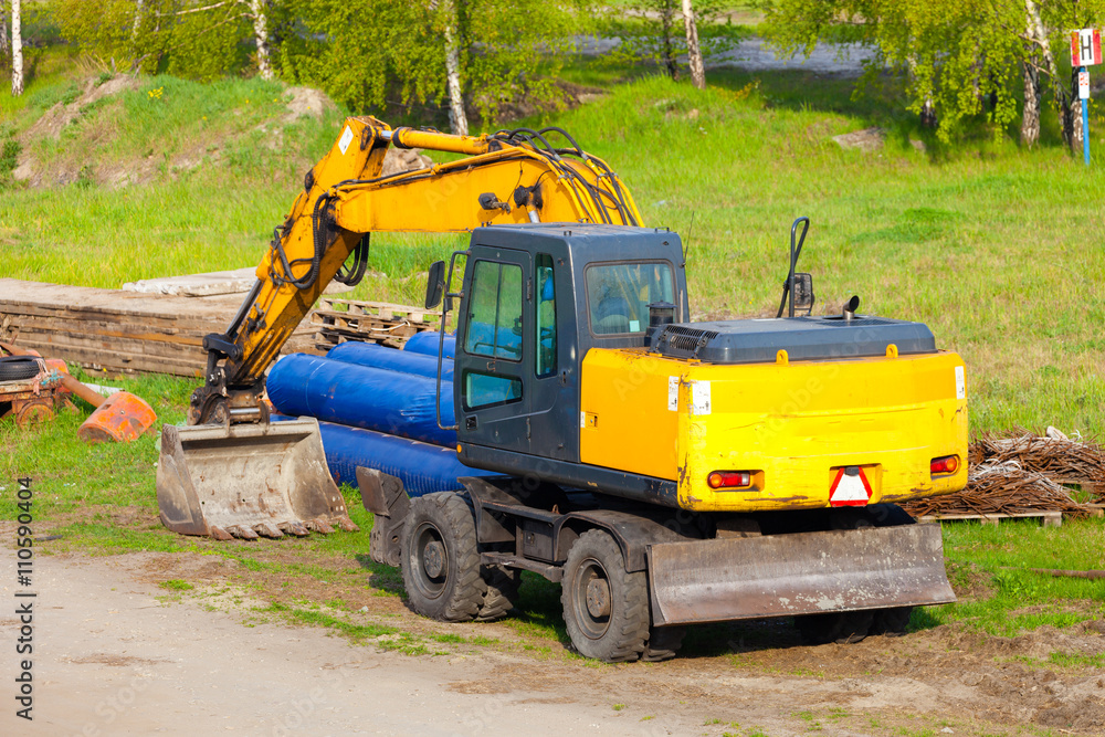 A big yellow excavator at construction site. A big yellow excavator at construction site.