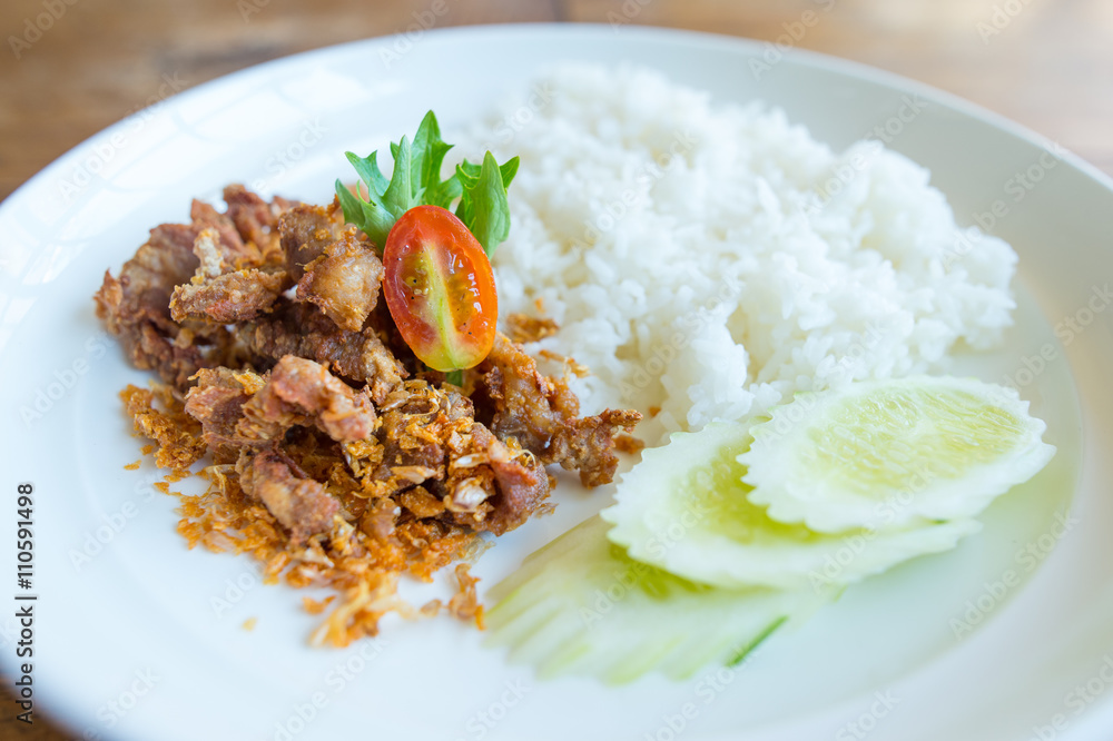 Pork fried with garlic and rice in white disk Pork fried with garlic and rice in white disk
