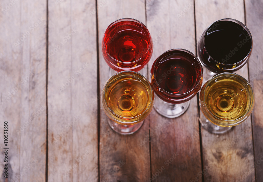 Glasses with wines of different colors on a wooden table Glasses with wines of different colors on a wooden table