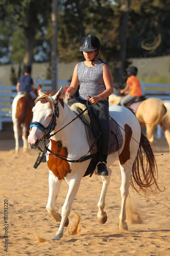 Teen girl is riding a horse