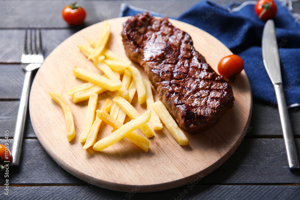 Grilled steak with french fries and cherry tomatoes, closeup Grilled steak with french fries and cherry tomatoes, closeup