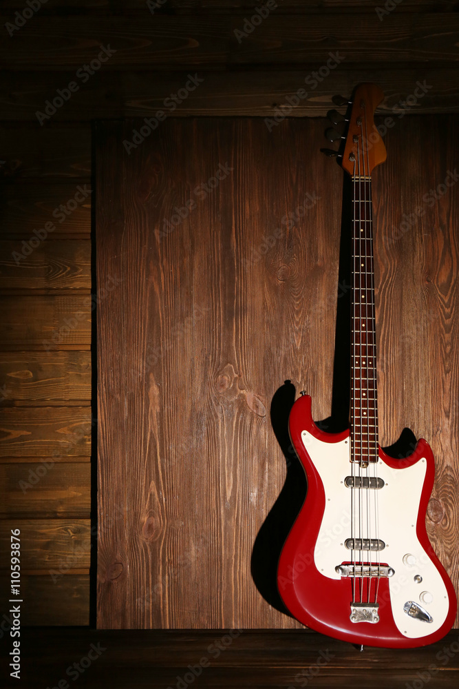 Fototapeta premium Electric guitar on dark lightened wooden background