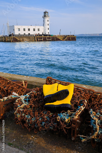 Trawlerman's protective yellow boots, and fishing gear in the harbour. In Scarborough, England. On 5th May 2016. photo