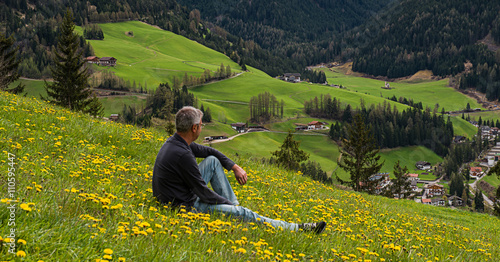 Man is relaxing in a field at Funes valley