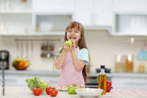 Little girl holding a green pepper.