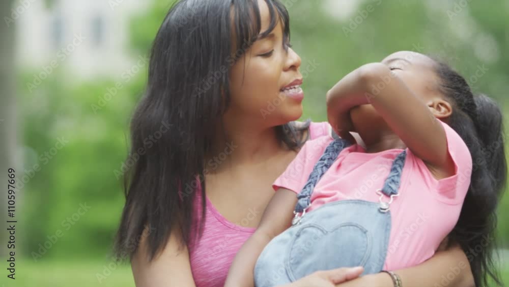 Portrait of happy African American mother & daughter having fun in the park. Portrait of happy African American mother & daughter having fun in the park.