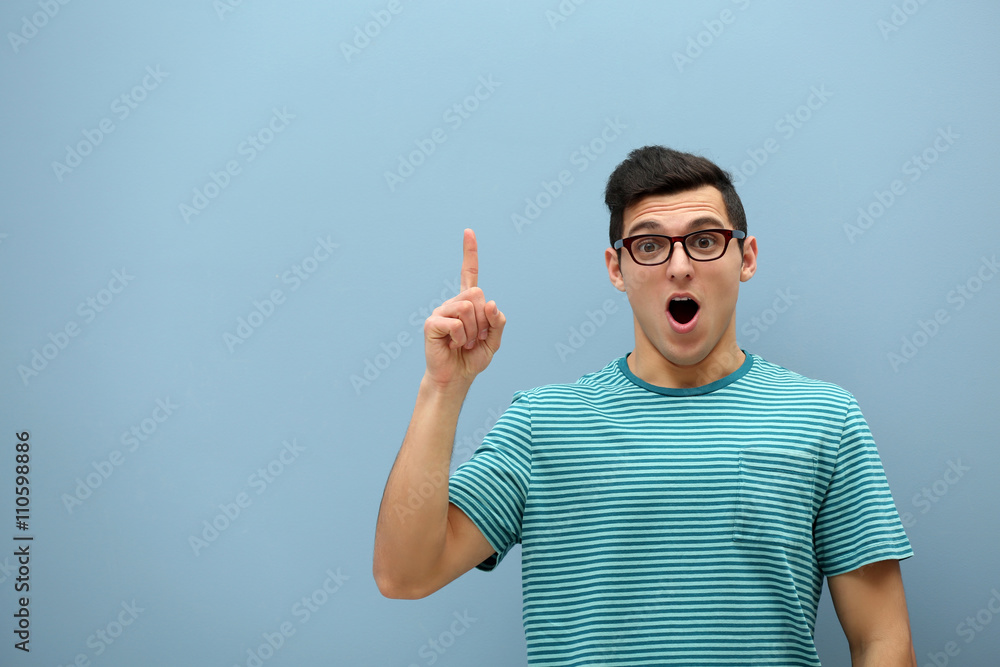 Attractive young man  against light blue wall