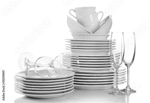 Stacked white clean plates, glasses and cups isolated on white