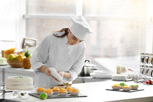Professional confectioner cooking delicious dessert at kitchen photo