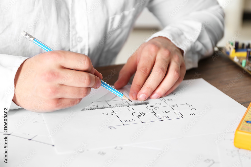 Male hands drawing electrical blueprints closeup Male hands drawing electrical blueprints closeup