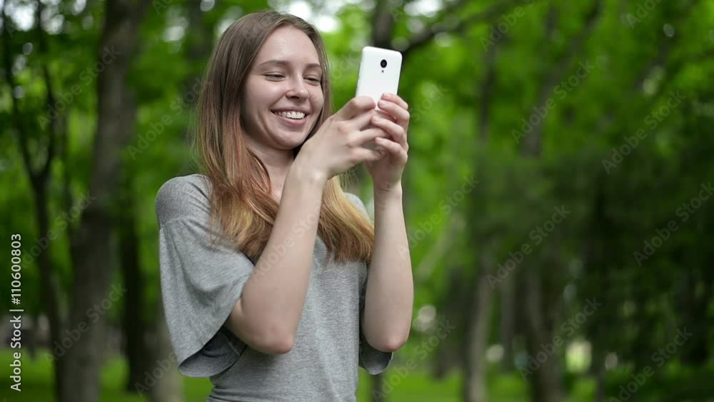 Beautiful woman uses cell smartphone outdoors in the park - detail Beautiful woman uses cell smartphone outdoors in the park - detail