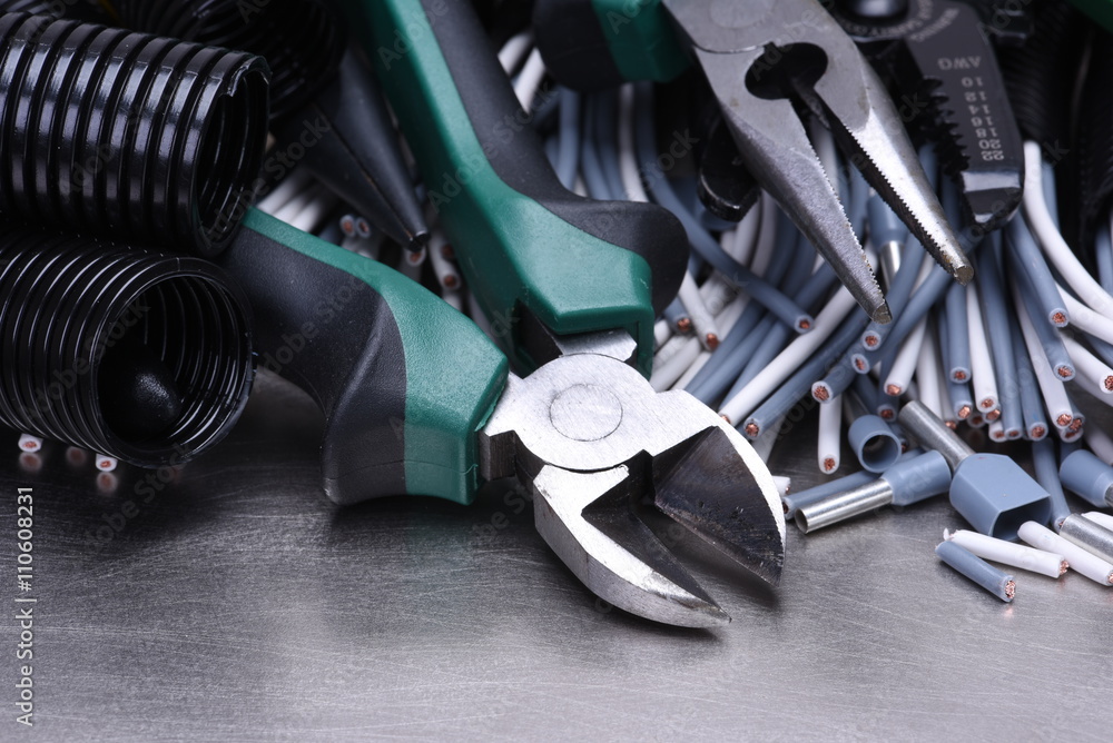 Tools for electrician and cables on grey metal surface Tools for electrician and cables on grey metal surface