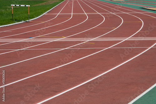 The running ways at the stadium with artificial coating of rubber and grass borders 