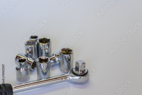 Set of sockets and ratchet. Mechanic tools in very soft focus. Isolated horizontal photo.