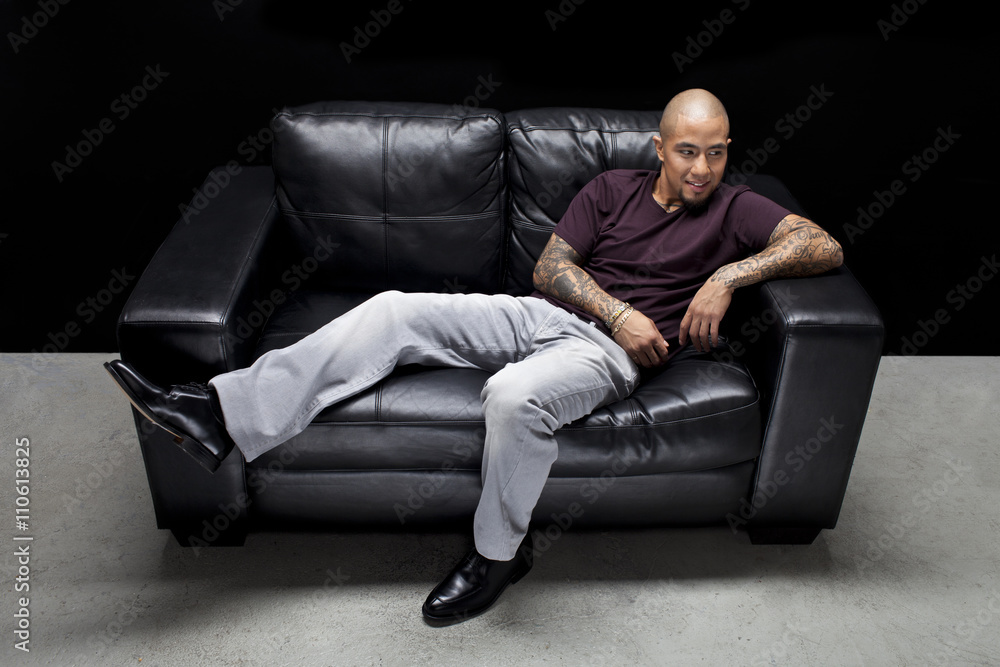 happy young man relaxing on couch. happy young man relaxing on couch.