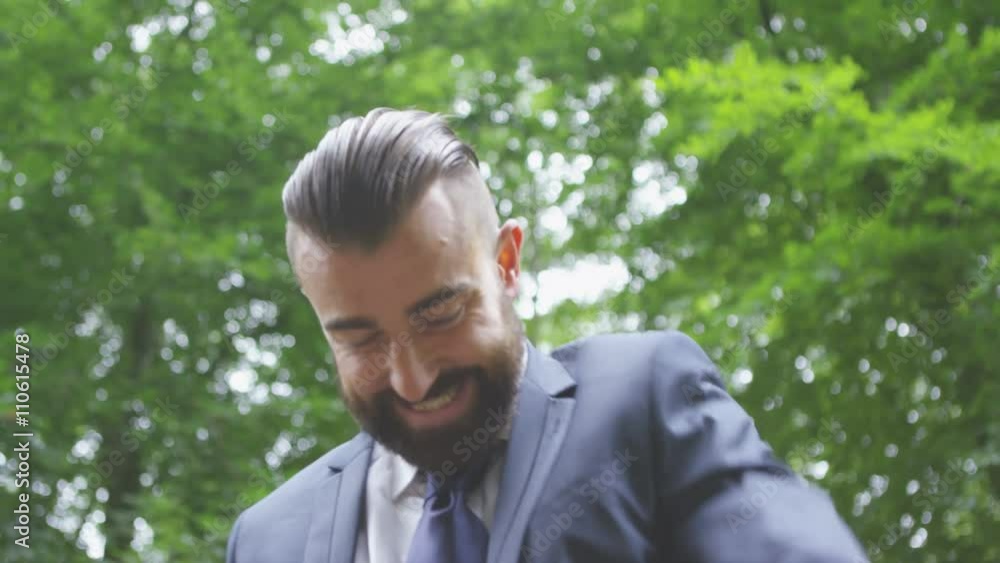 Excited hipster businessman punching the air, outdoors in the woods Excited hipster businessman punching the air, outdoors in the woods