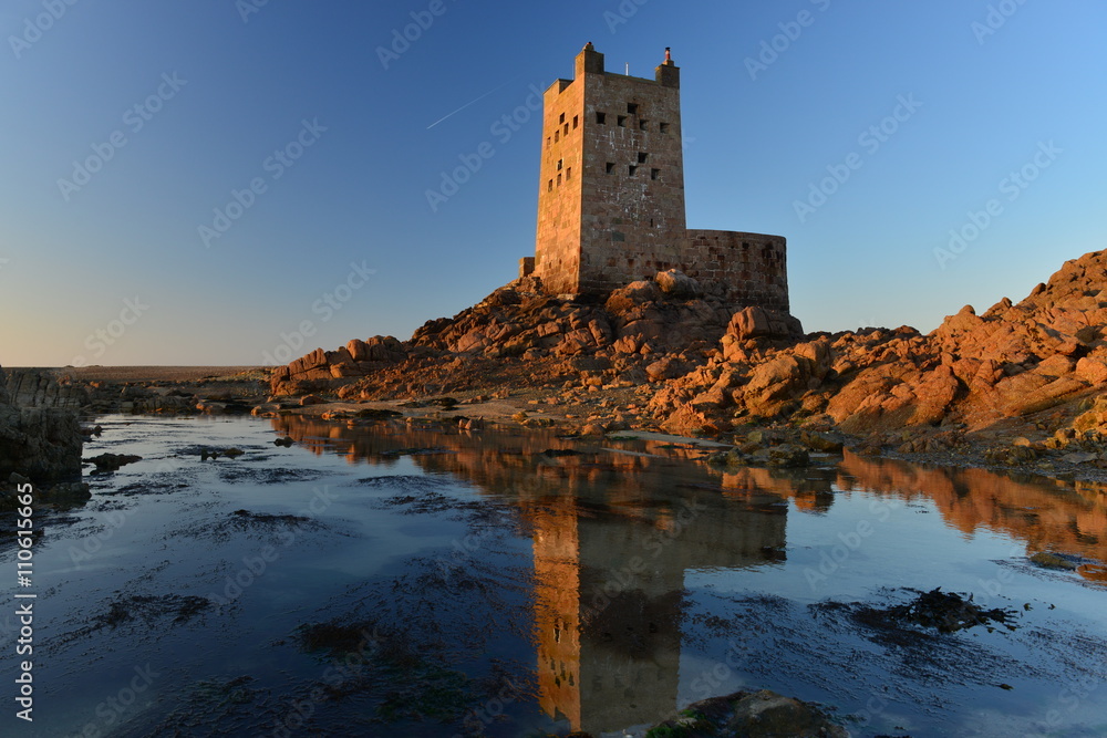 Seymour Tower, Jersey, U.K.    Wide angle image of a military 19th century Napoleonic Wars tower shot on a Spring low tide one mile from shore at sunset.