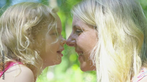  Happy affectionate mother & daughter rubbing noses together in the woods