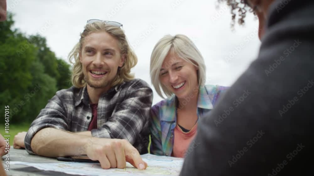 Happy group of friends hiking in the woods, sitting at table & looking at map. Happy group of friends hiking in the woods, sitting at table & looking at map.