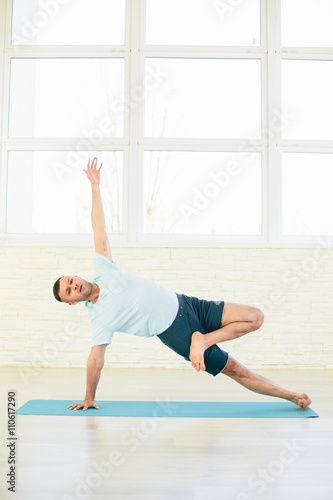Handsome yoga man practice in a training hall background. Yoga concept.