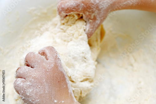 Child hands knead the dough