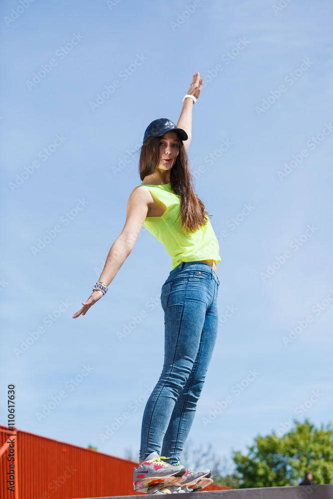 Teen girl skater riding skateboard on street. Teen girl skater riding skateboard on street.