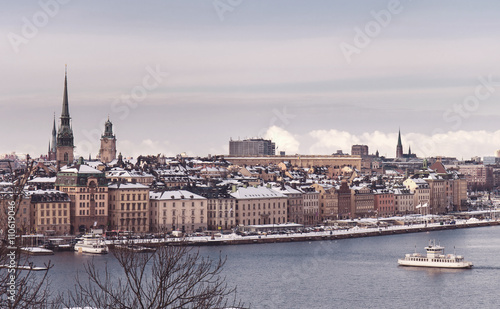 Vintage tinted snapshoot  Winter view over strait of Stockholm downtown. Boat onth water. Sweden photo